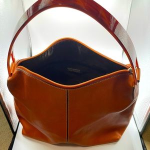 Adrienne Vittadini rust/orange purse with her handle.